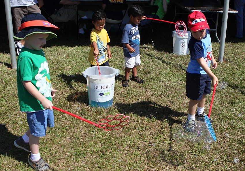 Stone Bass, 3, Kian and Kavi Riedi, 3, and Hudson Smith, 4, enjoy playing with bubbles at the GWiz station on Saturday, March 19 at the Sarasota Springfest out at Palmer Ranch.