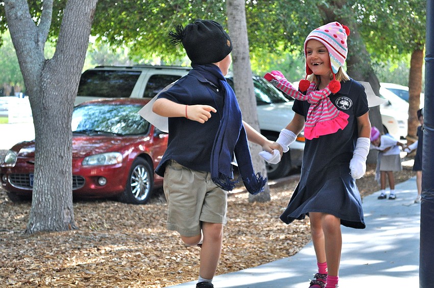 Will Hester and Madeline Frazier skip down the sidewalk.