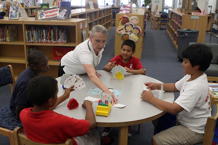 Kathy Lammert helps Kevin Garcia, Hevn Mendez, Anthony Spence and Charles Brantley with their game of bridge during the bridge club's final meeting Monday, May 23 inside Gocico Elementary School's Media Center.