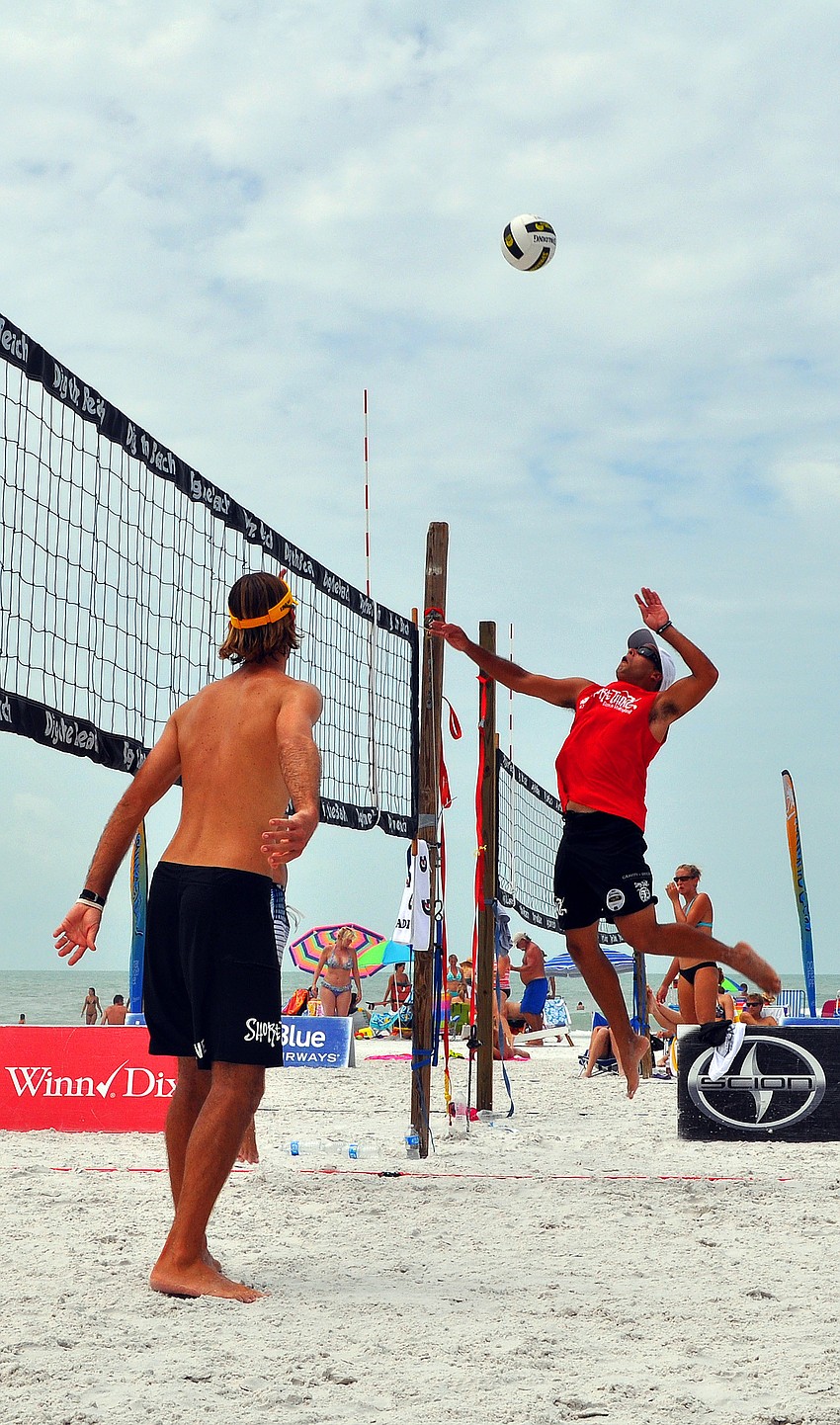 Adrian Carambula goes up to spike the ball as his teammate, Steve Grotowski, looks on during the Siesta Key Gulf Open, Saturday, July 9 at Siesta Key Beach.