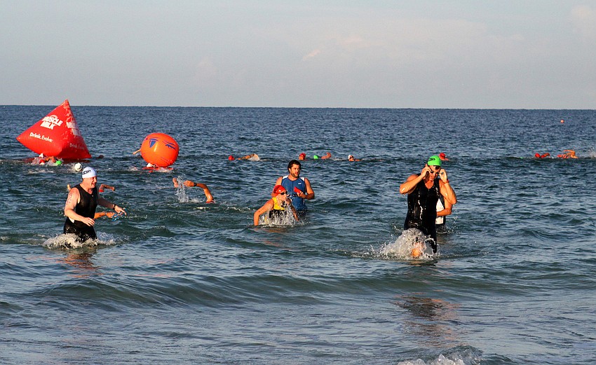 Participants make their way to shore after completing the swimming portion of the race Saturday, July 23 out at Siesta Key Public Beach.
