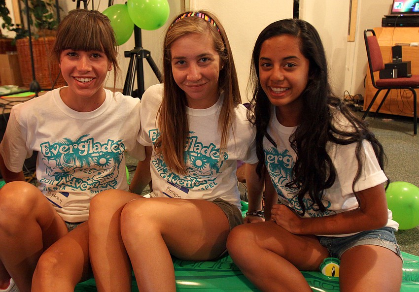 Camp volunteers Sydney Ralph, 14, Morgan Johnson, 14, and Kimberly Menezes, 15, pose on the alligator raft.