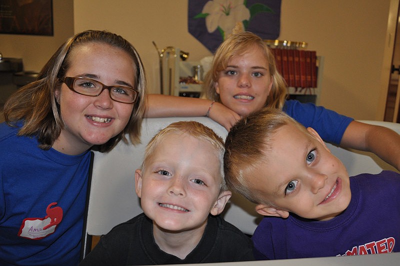 Volunteers Amanda McLaughlin and Sarah Lewis, behind, had fun with Jacob Neisen and Jacob Branson as they worked on their daily craft.
