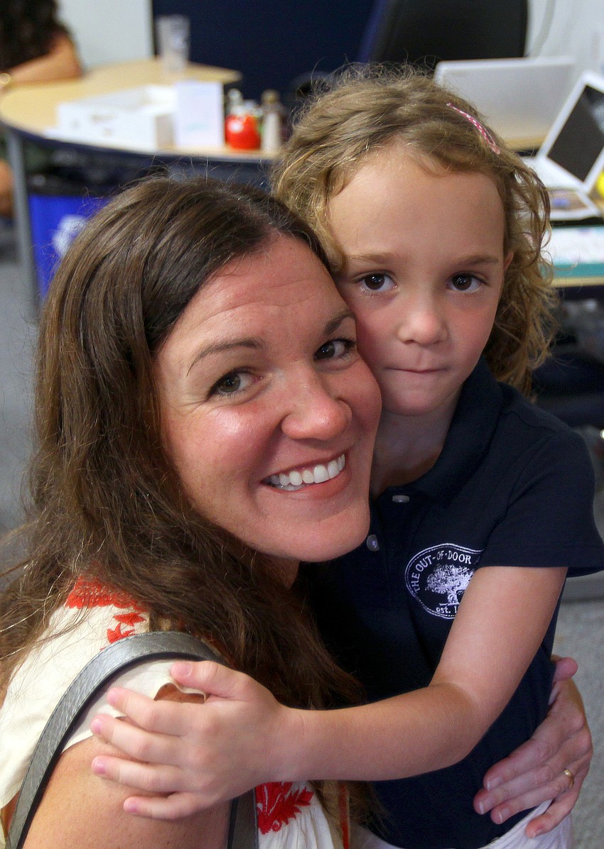 Lexi, 5, LaGasse gives her mom, Beth, a big hug and holds on tight Wednesday, Aug. 24 inside her Kindergarten classroom at Out-of-Door Academy.