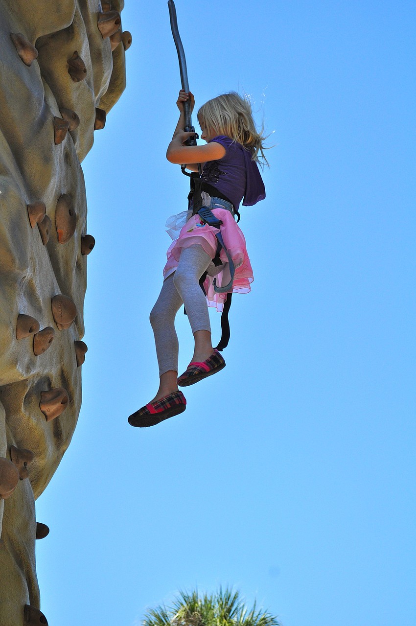 Claire Karp Hauser bounces off of the rock climbing wall.
