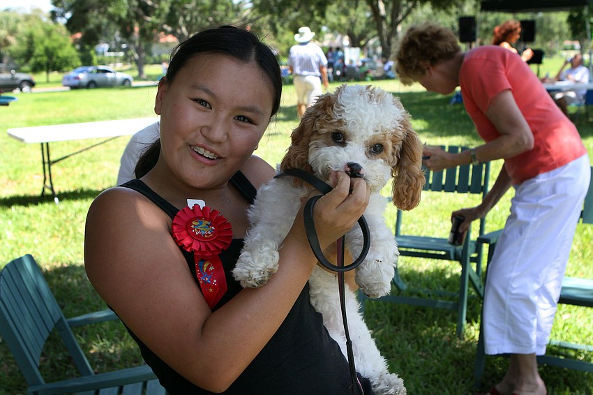 Sarah Burman, 16, holds up her neighbor's dog, Taffy, on Sunday, April 17 during South Bay's Family Fun Day. Burman won 2nd place in the cake or pie contest put on by the South Bay Women's Club with her chocolate raspberry pie.