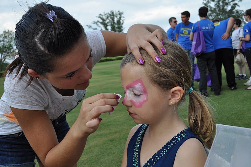 Ciara Garden paints a butterfly on the face of 8-year-old Hanna Swain.