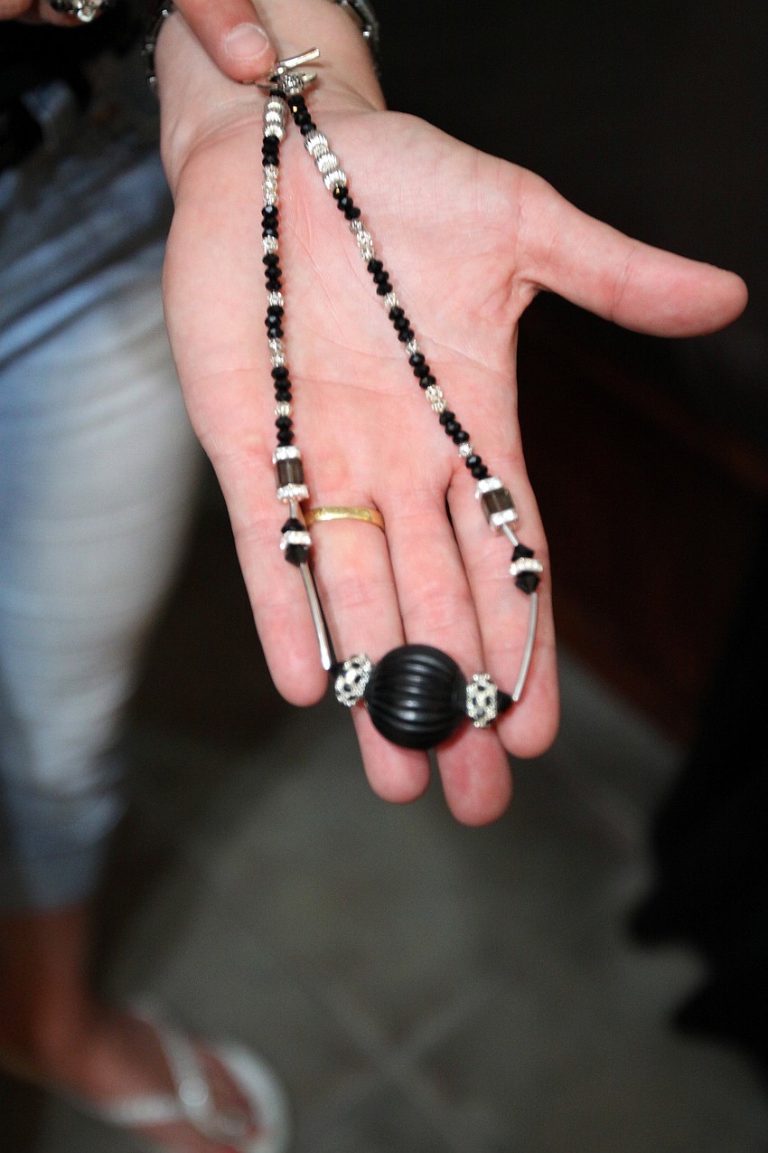 Jodi Valencic shows off a piece she designed and had made by Midgeann Schotsch Friday, May 6 during the Wine, Cheese and Beads event at Five Points Collective.