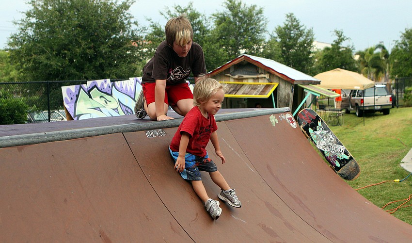 Cadell Gamber watches his brother Archer Hansen slide down a half pipe Saturday, May 14 during the Golden Era Tour event at Payne Park's skate park.