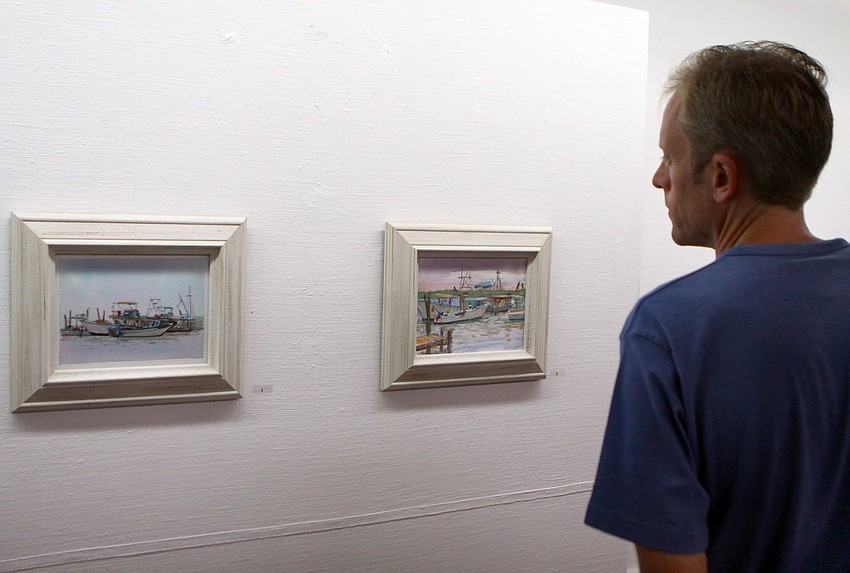 Eric Freeberg looks at some of Fiore Custode's paintings at the opening of the RCAD Creatives Exhibition Thursday, May 19 at Longboat Key Center for the Arts.