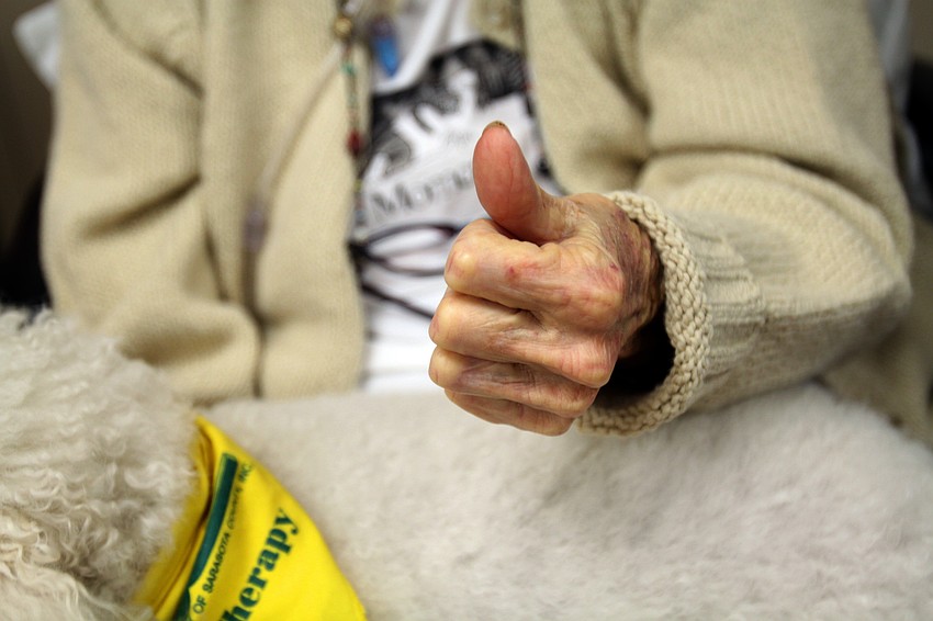 Virginia Sanders gives a thumbs up to the camera while Finnegan rests on her lap.