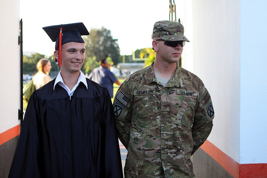 Otto Duerk stands next to his brother, Kyle Gempler, who came home from Afghanistan to surprise his Duerk and see him graduate from high school.