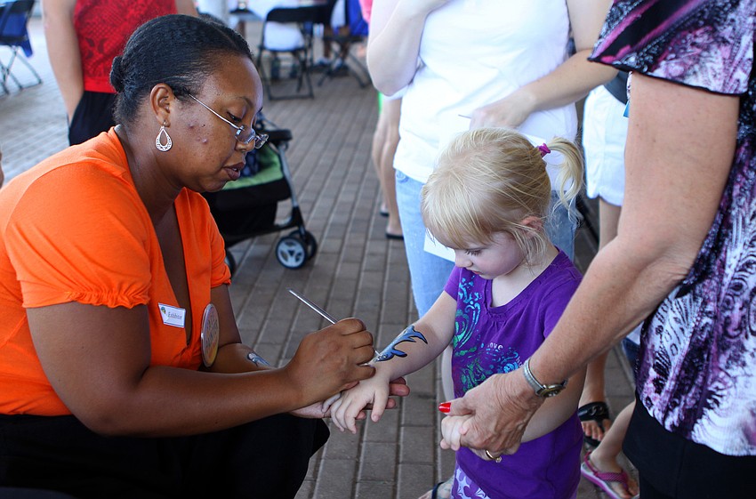 Nada Meeks paints a shark onto Alexis Cox's arm during the World Ocean Day Family Festival Sunday, June 5 at Mote Aquarium.