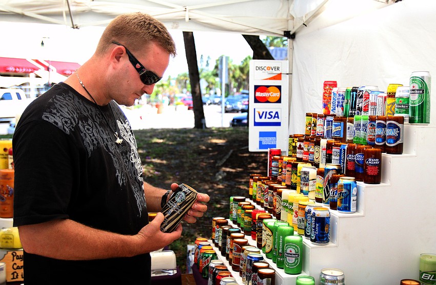 Terry Bodeker looks at some of the different candles made by Brandles at the 10th Annual St. Armands Craft Festival Saturday June, 11 at St. Armands Circle.
