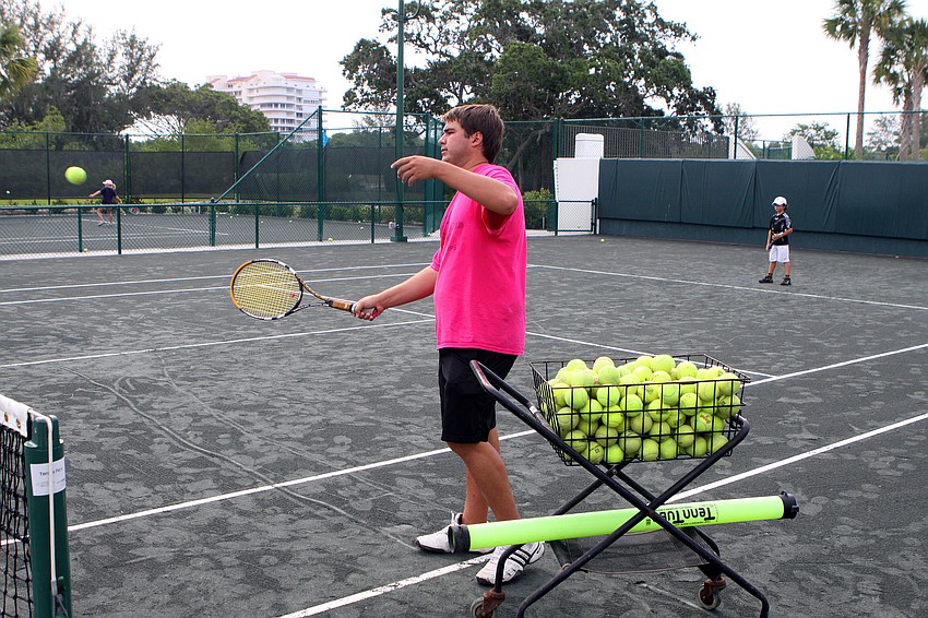 Tony Damai hits a ball over the net during a game of King of the Court during Longboat Key Club's Tennis Camp Monday, June 6 at Longboat Key Club's Tennis Gardens.