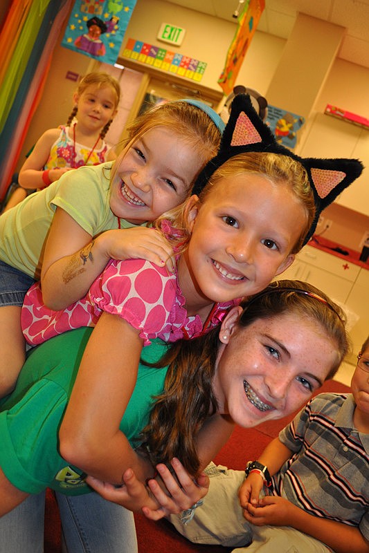 Sydney Prague and Molly Robinson piled on top of their group leader, Katie Wray.