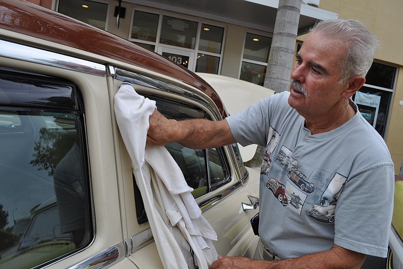 Bob Lignore wipes rain off his '53 Lincoln Cosmopolitan.