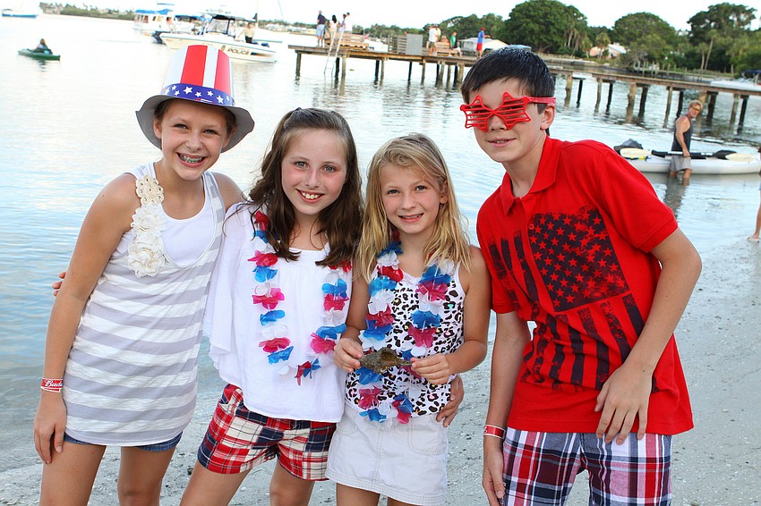 Holli Brown, 11, Elisabeth Laviolette, 9, Shyler Brown, 9, and Jack Laviolette, 12, pose with the hermit crab they found along the shore.