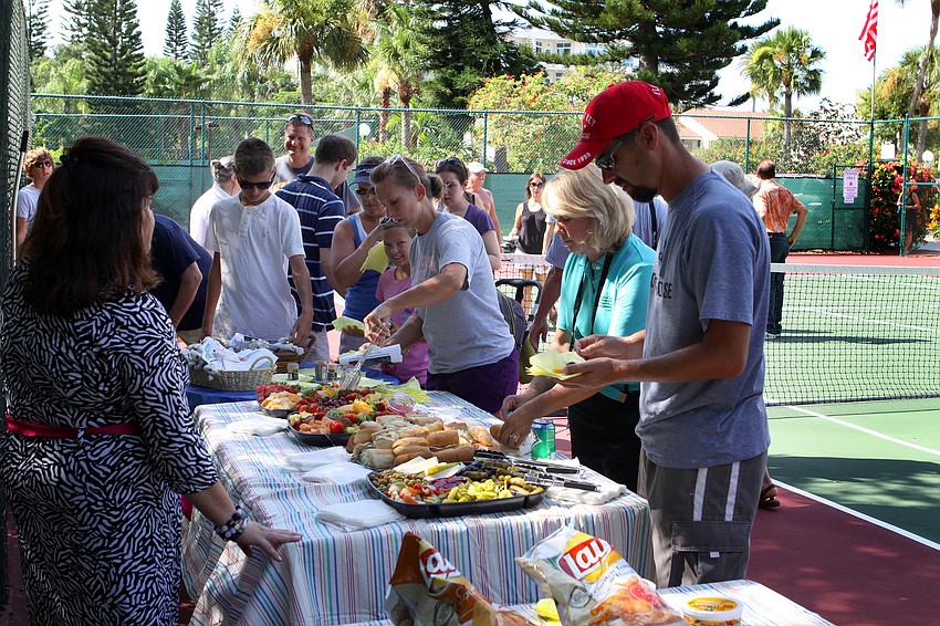 People enjoyed some food and beverages on the tennis courts while they waited for the official measuring of the cotton plant to begin.