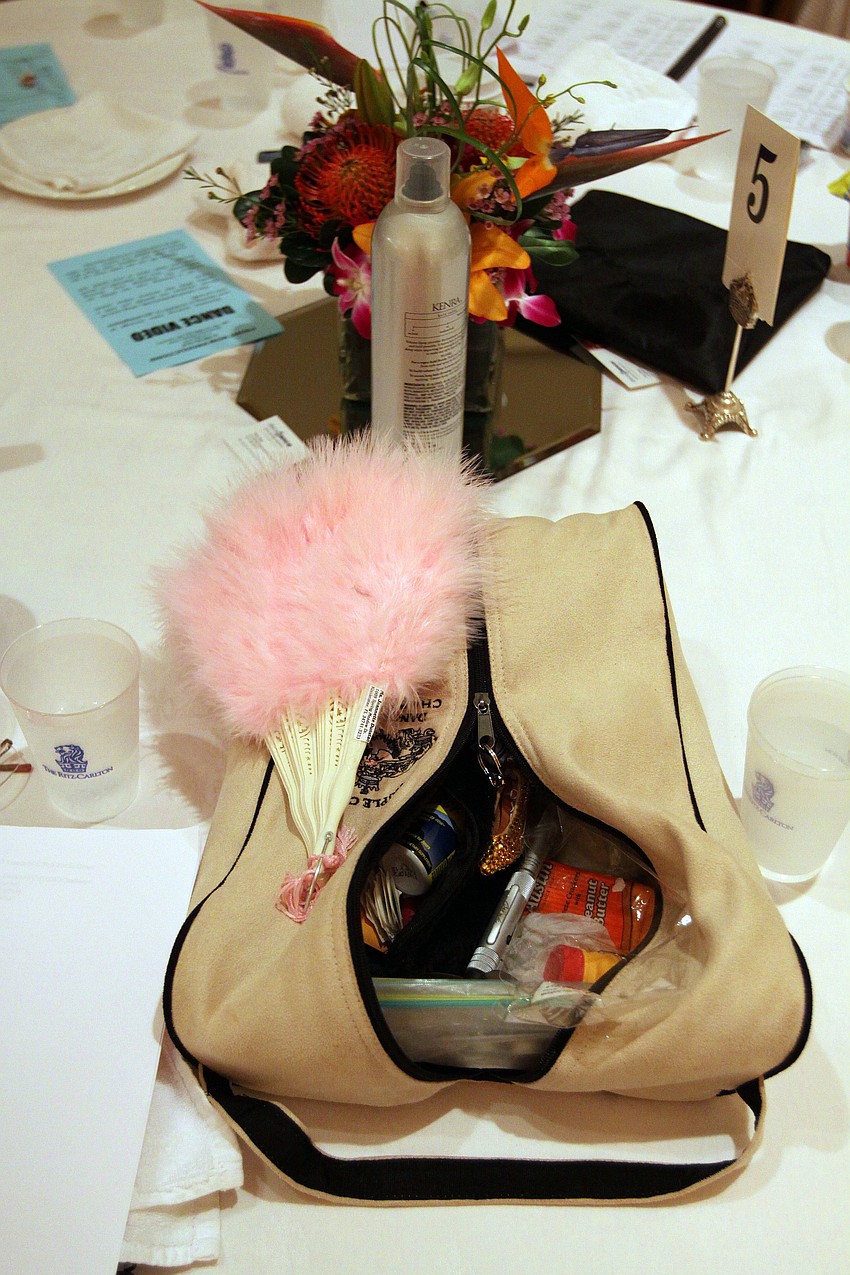 A bag of makeup along with a fan and some hairspray were on one of the many tables inside the ballroom.