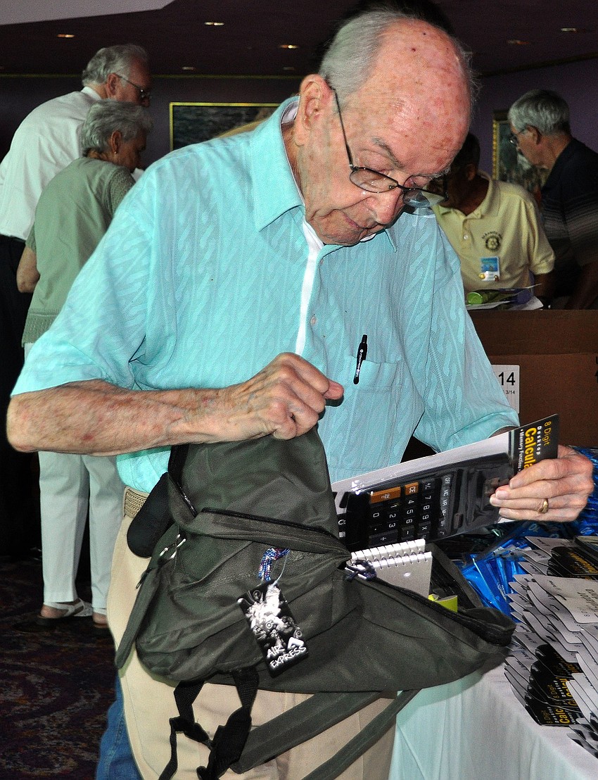 Joe Horne adds a calculator to one of the 800 backpacks that were being filled by the Sarasota Bay Rotary Club Tuesday, Aug. 16 at the Van Wezel.