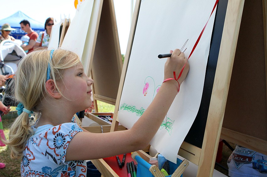 Sarah Catalano, 6, draws a rainforest on Saturday, March 19 at the Sarasota Springfest out at Palmer Ranch.