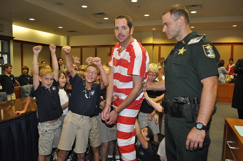 Students cheer as Lt. Joseph Guttman hauls away the Banyan thief.