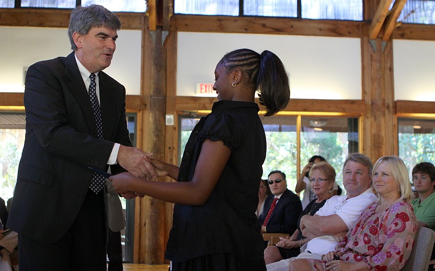 Kiarra Womack shakes hands with Headmaster Mahler while receiving the Citizen of the Year award.
