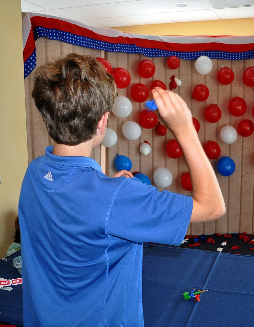 William Brunson, 13, plays darts Monday, July 4 at Bird Key Yacht Club.