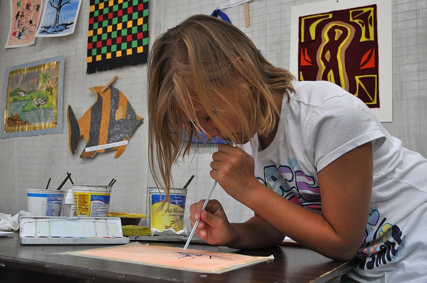 Isabella Thomsen, 9, blows through a straw to make tree limbs Friday, July 8 at the Art and Photography Studio of Colleen Cassidy.