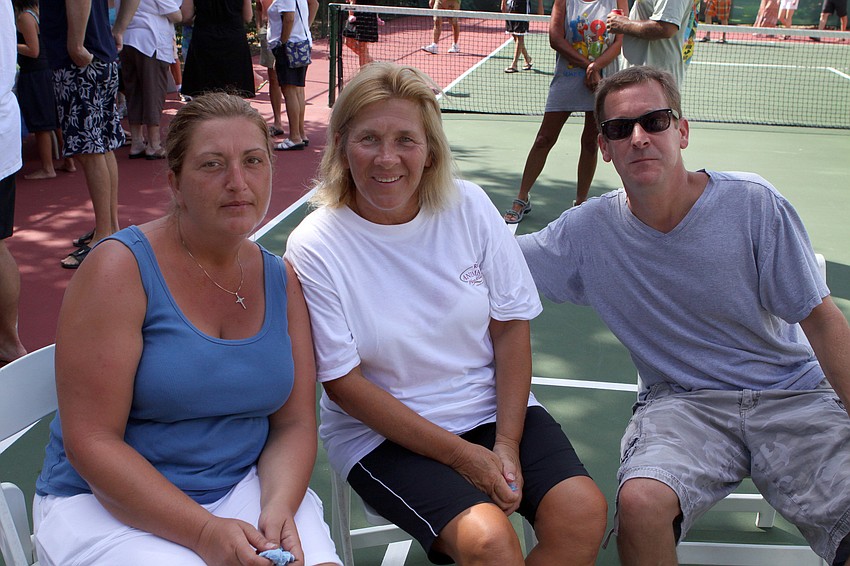 Bonnie Schneider, middle, brought her visiting daughter-in-law, Norma, and son, Chris, to see the measuring of the cotton plant.