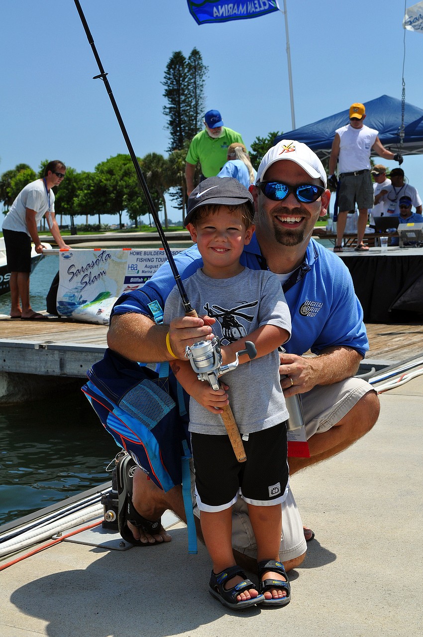 Jason Kebisiak poses with his son, Gavin, 3, after Gavin got a free fishing rod Saturday, August 6 during the Sarasota Slam weigh-in at Marina Jackâ€™s.