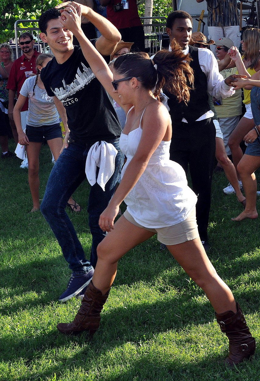 Javier Osorio-Gonzalez dances with flash mob leader Dana Bakich Friday, August 12 during Friday Fest at the Van Wezel.