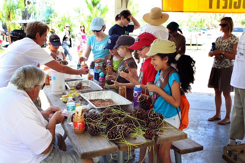 Girl Scouts get ready to make treats for birds with pinecones, birdseed and peanut butter at the Veince Audubon Society Table during the Earth Day Celebration on Sunday, April 17 out at Oscar Scherer State Park in Osprey.