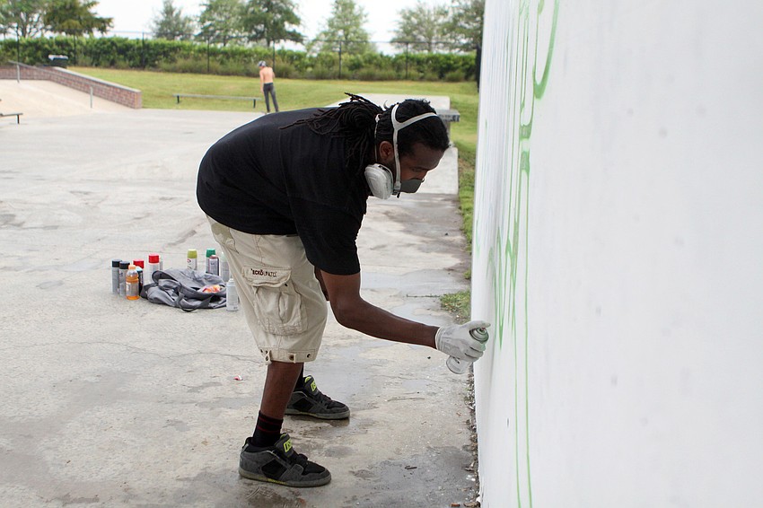 Tion Bukue starts his graffiti art on a wall at the skate park during the Golden Era Tour event at Payne Park.