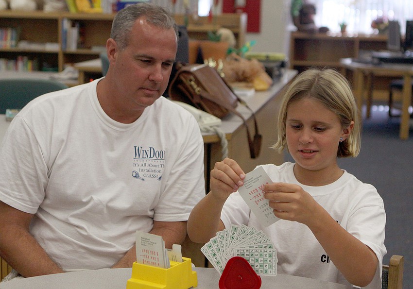 Mike Worthley watches his daughter, Joey, play bridge during the bridge club's final meeting Monday, May 23 inside Gocico Elementary School's Media Center.