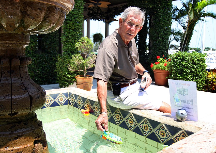 David Perry, the Commodore of the Longboat Key Club Yacht Club, picks a boat out of the water fountain to see if he can win a prize during National Marina Day Saturday, June 11 at Longboat Key Club's Marina.