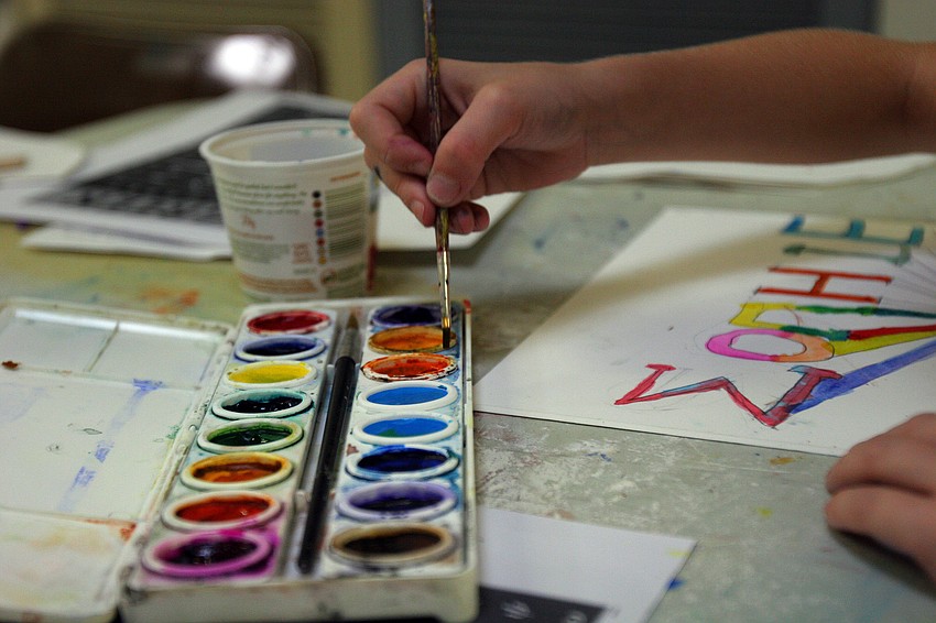 Sophie Winer coats her brush in an orange paint from her paint set Tuesday, June 14 during the It's All Greek To Me! summer art class at Art Center Sarasota.