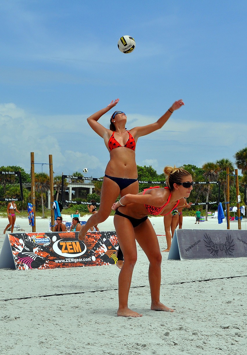 Livia Mendonca serves the ball while her teammate, Melissa Roberts, stays on her toes during their game against Kendra Van Zweiten and Shayna Munson in the Siesta Key Gulf Open, Saturday, July 9 at Siesta Key Beach.