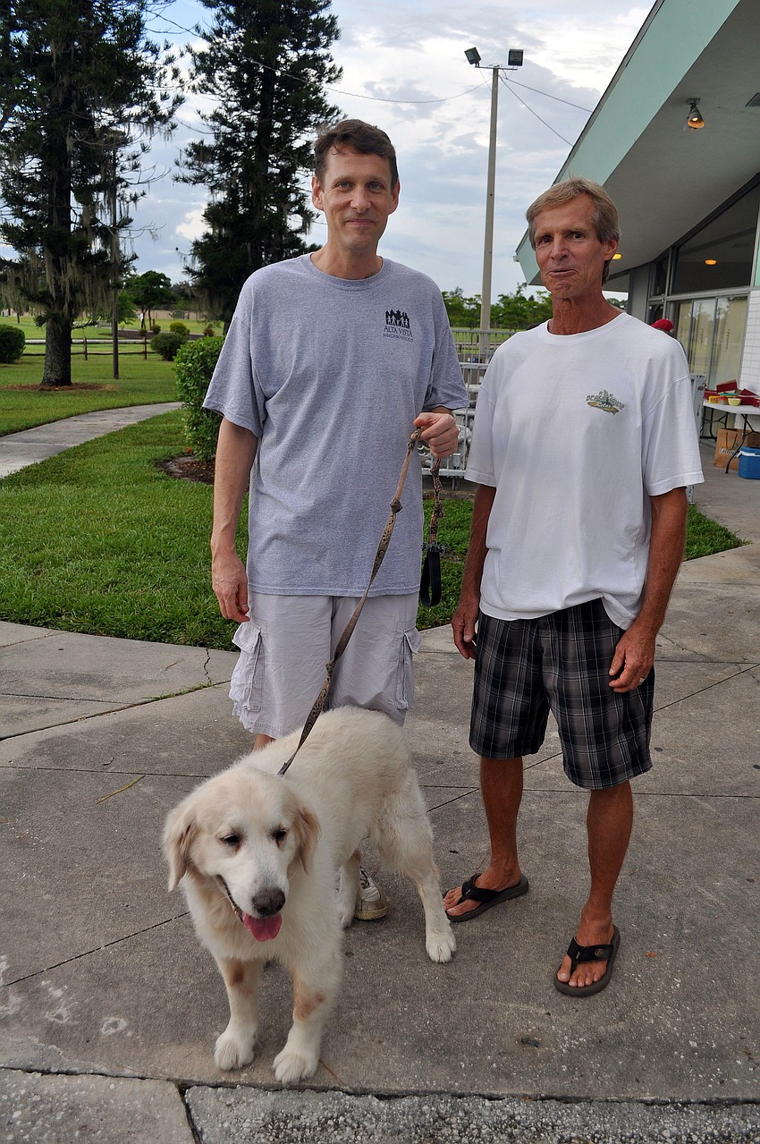 Jay Portman and Rick Mangold hang out with Moby, one of the Kirschner's dogs, Thursday, July 28 during the Alta Vista neighborhood picnic at Payne Park.