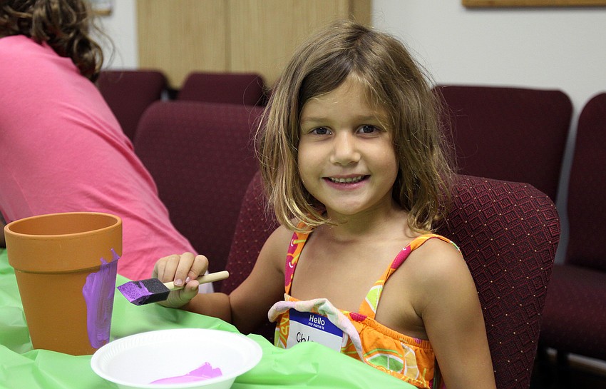 Chloe Johnson, 6, paints her pot purple during craft time at â€œEverglades Adventureâ€ vacation bible school.