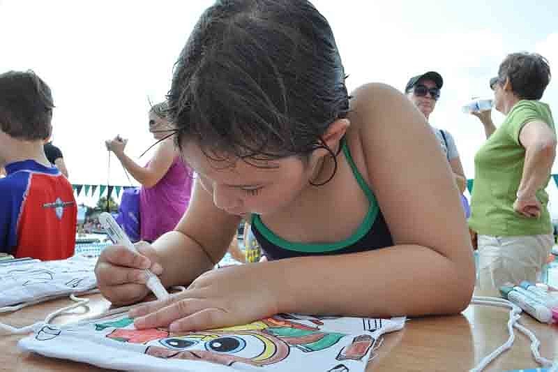 Caryn Smeiser, 6, eagerly colored a backpack for herself.