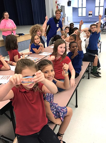 Students at Wadsworth Elementary School hold up their bracelets, which were given to remind them to eat five servings of fruits and vegetables every day. Photo courtesy of Florida Hospital Flagler
