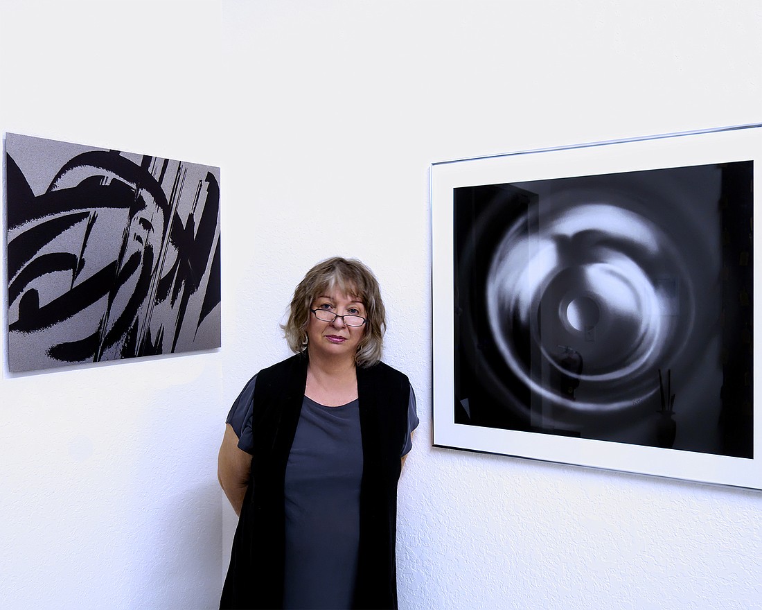 Krystyna Spisak-Madejczyk stands between two of her works at the Blue Art Gallery in Bunnell. Courtesy photo