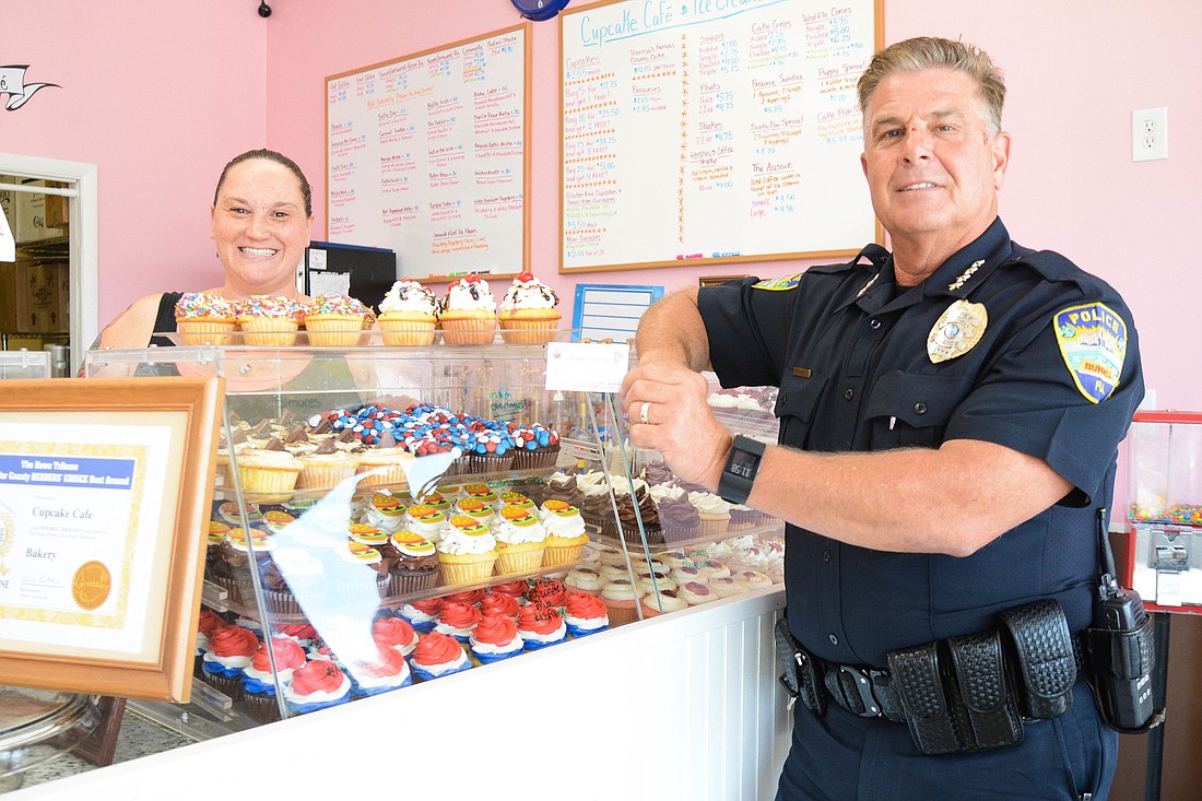 Cupcake CafÃ© owner, Theresa Tazwell, and Bunnell Police Chief Tom Foster pose with a "cupcake citation." Photo by Paige Wilson