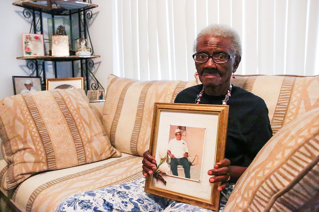 Luella Johnson, 95, holds up a photo of her late husband Harry Johnson. Photo by Paige Wilson