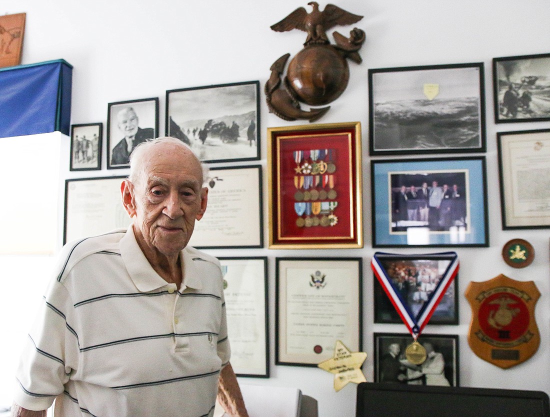 Bob Bey, 92, stands in front of his military awards, including his two Purple Hearts. Photo by Paige Wilson
