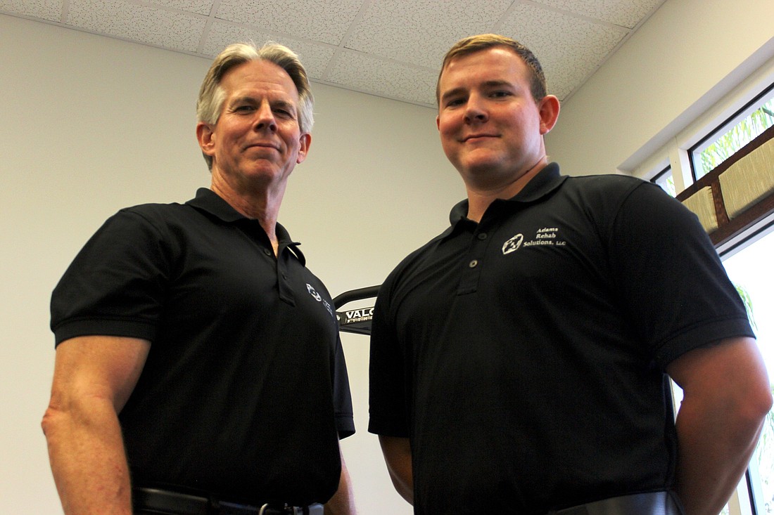 Tom Adams recently hired his 27-year-old son, Eric Adams, at Adams Rehab Solutions. Photo by Ray Boone
