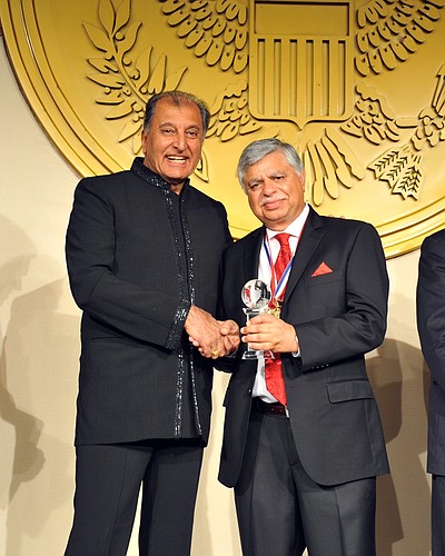 Khalid Muneer (right) recieves the International Leadership Award for his role in growing central Florida's Asian-American business community. Photo courtesy of Bob Lo