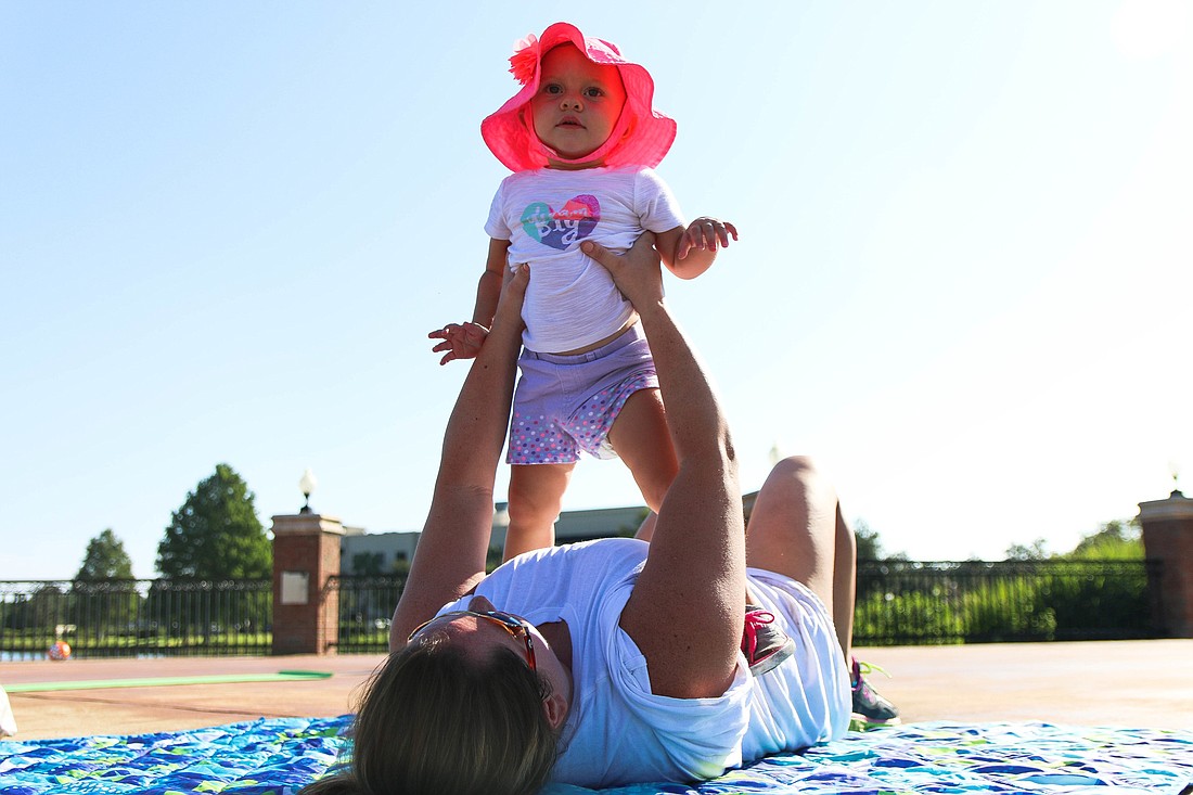 Jennifer Graves holds up her 1-year-old daughter Breelyn during the Mommy and Me Fit Camp on Aug. 18. Photo by Paige Wilson